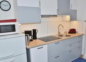 a kitchen with white cabinets and a sink and a microwave at Kunst&Handwerk in Eckernförde +7 photos