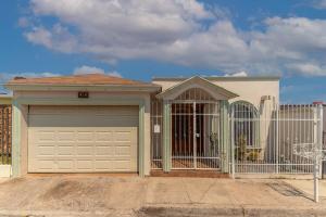 a house with a garage door and a fence at Comfortable and family house Eva Pet friendly in Chihuahua