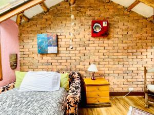 a bedroom with a brick wall and a bed at Varsovia, casa de madera biblioteca in Guatavita