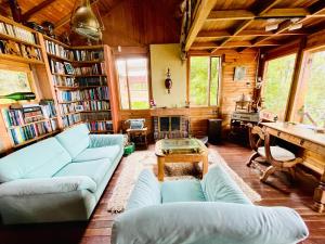 a living room with couches and a table and books at Varsovia, casa de madera biblioteca in Guatavita