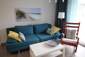 een woonkamer met een blauwe bank en een stoel bij Dock 31 in Neuhaus