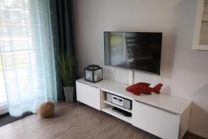 een woonkamer met een tv op een witte kast bij Dock 31 in Neuhaus