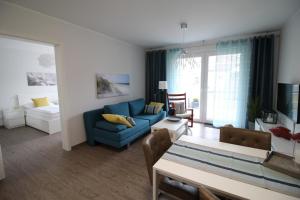 een woonkamer met een blauwe bank en een tafel bij Dock 31 in Neuhaus