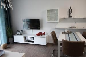 een witte woonkamer met een tv en een tafel bij Dock 31 in Neuhaus +17 foto's