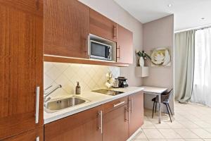 une cuisine avec un évier et un micro-ondes dans l'établissement Augarten Suites I 5 min to Metro I 10 Min to City, à Vienne