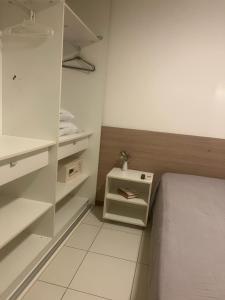 ein kleines Schlafzimmer mit einem Bett und weißen Schränken in der Unterkunft Iloa Resort Residence 001C in Barra de São Miguel