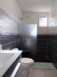 a bathroom with a toilet and a tub and a sink at Les Hauts de Beline Petit-Havre in Le Gosier