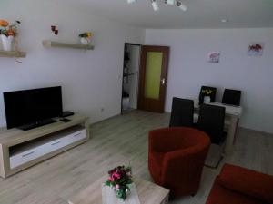 a living room with a flat screen tv and chairs at Maggie&#039s Goode Stuuv in Heiligenhafen
