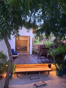 a wooden deck with a bench and a fireplace at Casa Ninho in Atins