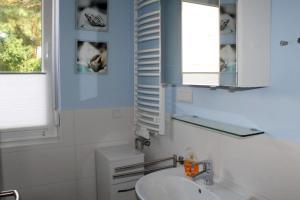 a bathroom with a sink and a mirror and a window at Seeschwalbe App 34 in Neuhaus