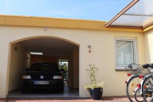 M5 Bungalow - Apartmenthaus Marienburger Str 4 - FERIENDOMIZIL HOLLICH في غروميتز: سيارة متوقفة في كراج منزل