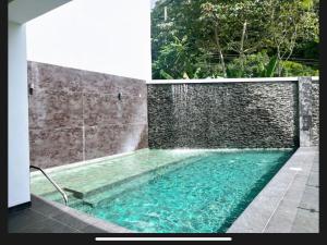 a swimming pool with a waterfall and a stone wall at Beachfront Condo Stunning Views in Jacó