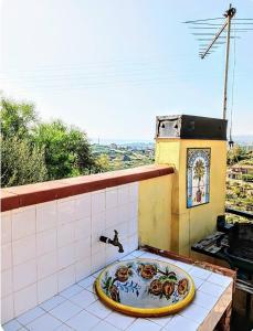 y baño con lavabo sobre una cornisa de azulejos. en Flat with panoramic terrace and private pool mt5x3, en Taormina