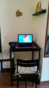 un ordenador portátil sentado en un escritorio con una silla en Flat with panoramic terrace and private pool mt5x3, en Taormina