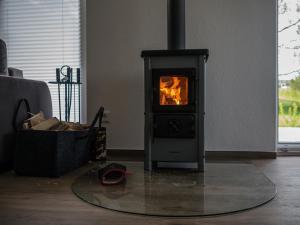 a stove in a living room with a fire in it at Ferienhaus Ruheoase im Müritz Seepark in Röbel