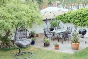un patio con tavolo, sedie e ombrellone di Mien Tied ACHTERN a Heiligenhafen