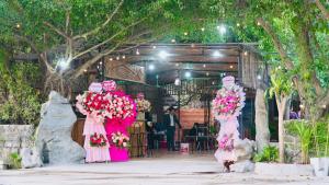 a group of women in pink dresses holding flowers at Ali Garden Homestay Tràng An Ninh Bình in Xuân Sơn