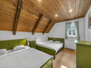 due letti in una stanza con soffitti in legno di Villa in Cerna Hora near Ski Resorts a Horní Maršov