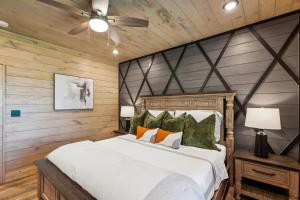 a bedroom with a large white bed and wooden walls at Honeybear Hideaways - #1 Luxury Haven Cabin with Breathtaking Mountain Views, Indoor Pool, Bowling Alley, and Golf in Pigeon Forge +37 photos