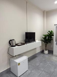 a living room with a tv on a white wall at Your Lifestyle Guesthouse in Patong Beach