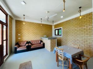 a room with a table and chairs and a brick wall at CDR Eco Home in Weligama