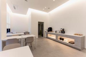 a room with white walls and tables and chairs at La Scene Hotel in Pyeongtaek