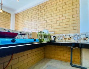 a kitchen with a blue counter and a brick wall at CDR Eco Home in Weligama +36 photos