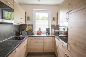 レーベルにあるFerienhaus Seebad im Müritz Seepark 41 aのキッチン(木製キャビネット付)、窓