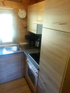 a kitchen with a stove and a sink and a clock at Blockhaus Bayerischer Wald in Stamsried