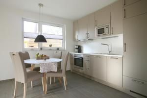 a kitchen with a table and chairs and a kitchen with white cabinets at "Strandhus Fink" in Dierhagen