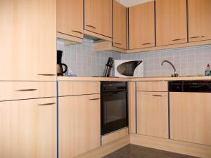 a kitchen with wooden cabinets and a sink at Meeresbrise 06 in Neuhaus