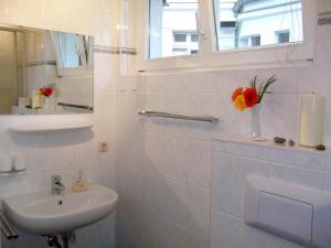 a white bathroom with a sink and a mirror at Meeresbrise 06 in Neuhaus