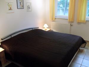 a bedroom with a bed with a black bedspread and a window at Meeresbrise 06 in Neuhaus +4 photos