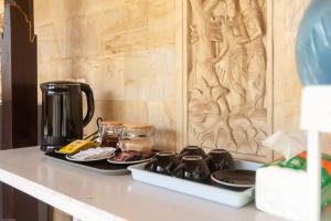 a coffeemaker sitting on a kitchen counter with two plates at The Cube Hostel Penida in Sampalan