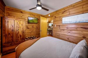 a bedroom with wooden walls and a bed in a room at Couples Getaway Cabin near National Park w Hot Tub in Pigeon Forge