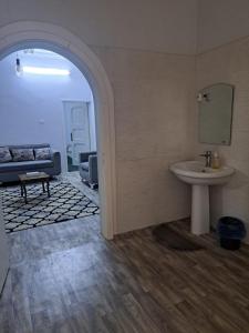 a bathroom with a sink and a mirror and a couch at شقة مفروشة in Al Baha