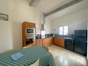 a kitchen with a bed and a black refrigerator at Maison pour 5 pers avec terrasse à Saintes-Maries-de-la-Mer - FR-1-475-163 in Saintes-Maries-de-la-Mer +6 photos
