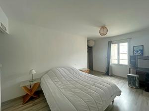 a white bedroom with a large bed and a window at Maison pour 5 pers avec terrasse à Saintes-Maries-de-la-Mer - FR-1-475-163 in Saintes-Maries-de-la-Mer