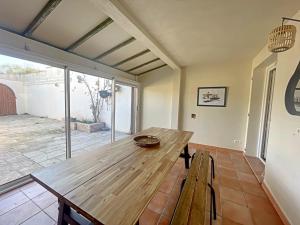 drewniany stół w pokoju z patio w obiekcie Maison 6 personnes avec cheminée aux Saintes-Maries-de-la-Mer - FR-1-475-162 w Saintes-Maries-de-la-Mer