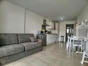a living room with a couch and a kitchen at Studio 4 pers climatisé avec parking, à 100m de la mer - FR-1-475-174 in Saintes-Maries-de-la-Mer +3 photos