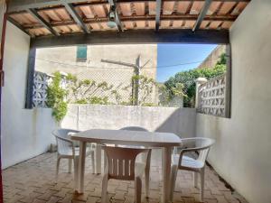 une table et des chaises sur une terrasse avec une fenêtre dans l'établissement Studio 4 pers avec Parking aux Saintes-Maries-de-la-Mer - FR-1-475-176, à Saintes-Maries-de-la-Mer