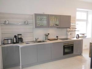 a kitchen with grey cabinets and a sink at Mien Tied an Deck in Heiligenhafen
