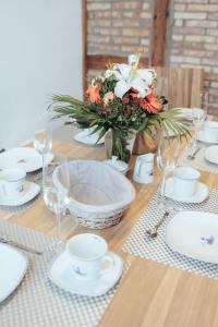 a wooden table with a vase of flowers and glasses at Mien Tied an Deck in Heiligenhafen