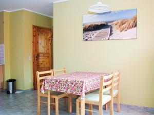 a dining room with a table and chairs and a picture of a beach at Hütigendachs, FW 4 in Zingst