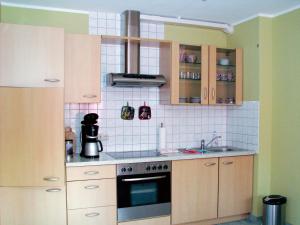 a kitchen with a sink and a stove top oven at Hütigendachs, FW 4 in Zingst