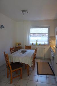 a kitchen with a table and chairs in a kitchen at Ferienhaus Kröger-Scholz Ferienwohnung über 2 Etagen in Papenburg-Obenede