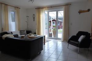 a living room with a couch and two chairs at Ferienhaus Kröger-Scholz Ferienwohnung über 2 Etagen in Papenburg-Obenede +16 photos
