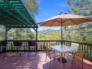 a patio with a table and chairs and an umbrella at Whole House at Eaglenest Inn with Pool & Seasonal SPA in Julian
