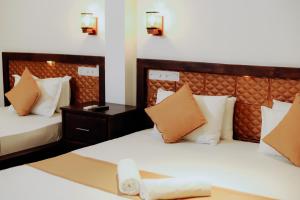 a hotel room with two beds and a table at Sharta Yala in Tissamaharama