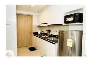 eine Küche mit einem Kühlschrank aus Edelstahl und einer Spüle in der Unterkunft Shore residences tower D Staycation near Sm moa in Manila
